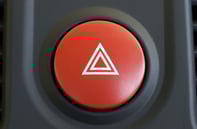 Red circular button from car interior with white triangle to use to turn on hazard lights of car