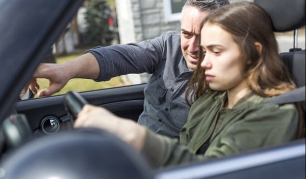 Dad showing teen girl driver how to drive a car