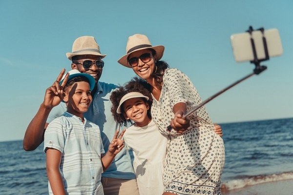Happy family taking selfie outside car on vacation 2-1