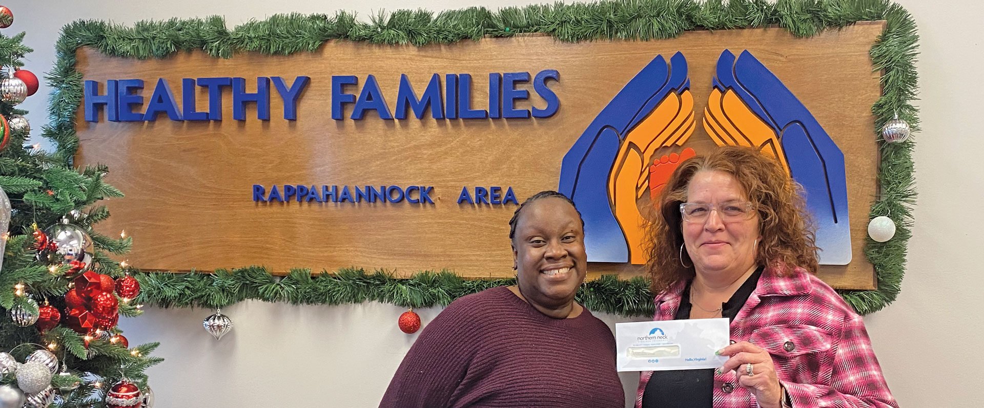 Two women accepting check at Healthy Families