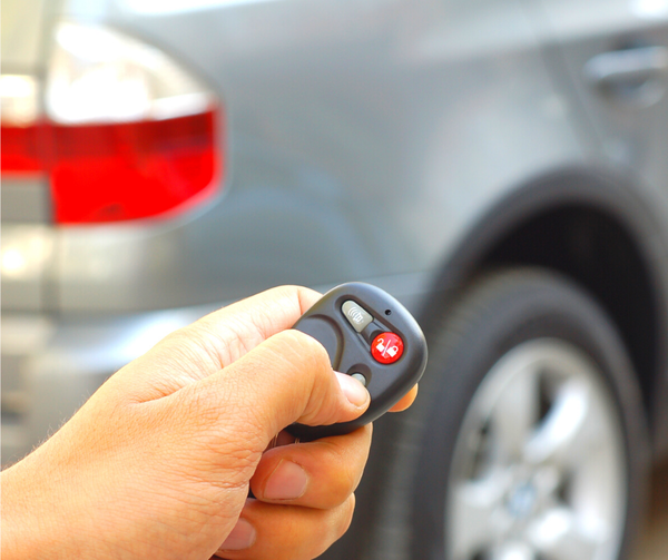 Human hand on car keyless remote locking car behind it-1