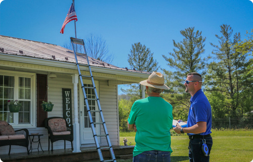 homeowner standing with insurance adjuster assessing roof