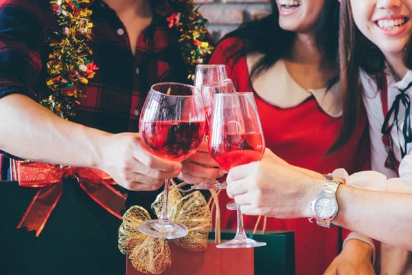 group of holiday happy party goers toasting with wine glasses