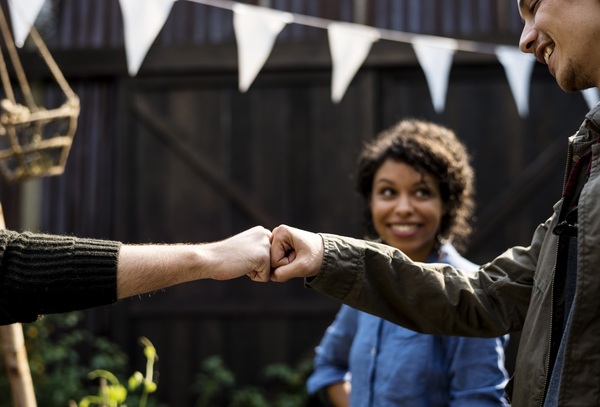 two men fist pumping and smiling while happy woman watches-1